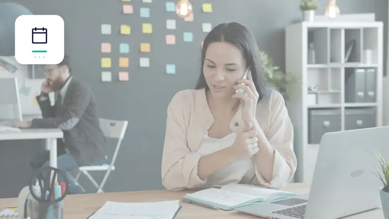 Profesional atendiendo por teléfono a un cliente junto a un portátil con calendario y marca de plazo – imagen editorial para «Evitar cuentas pendientes con mejores condiciones de pago».