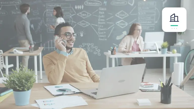 Profesional en una oficina moderna con portátil y teléfono con símbolo de empresa – imagen editorial para «Cuentas por cobrar pendientes frente a consumidores: cómo estructurar comunicación y mora de forma clara».