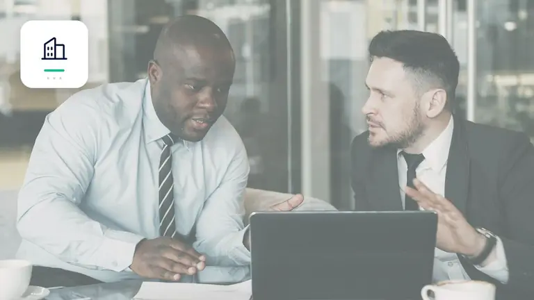 Dos profesionales revisando conjuntamente un asunto empresarial con símbolo de empresa – imagen editorial para «Cuentas por cobrar pendientes en negocios B2B: intereses, recargo fijo e indemnización».