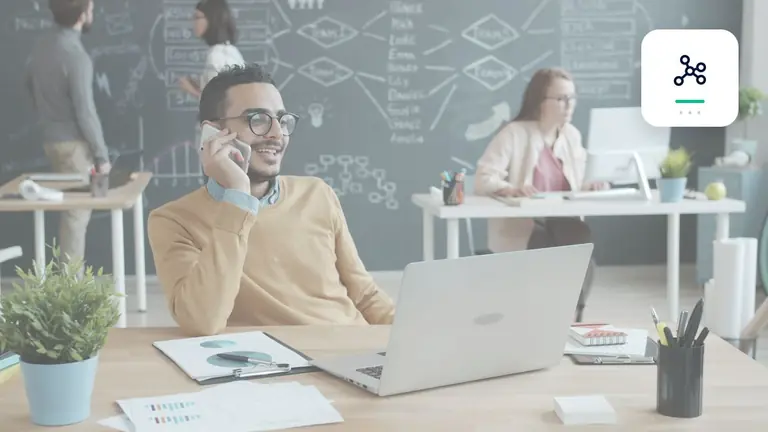 Profesional en una oficina moderna con portátil y teléfono con red digital de procesos – imagen editorial para «Reducir cuentas pendientes con recordatorios automatizados».