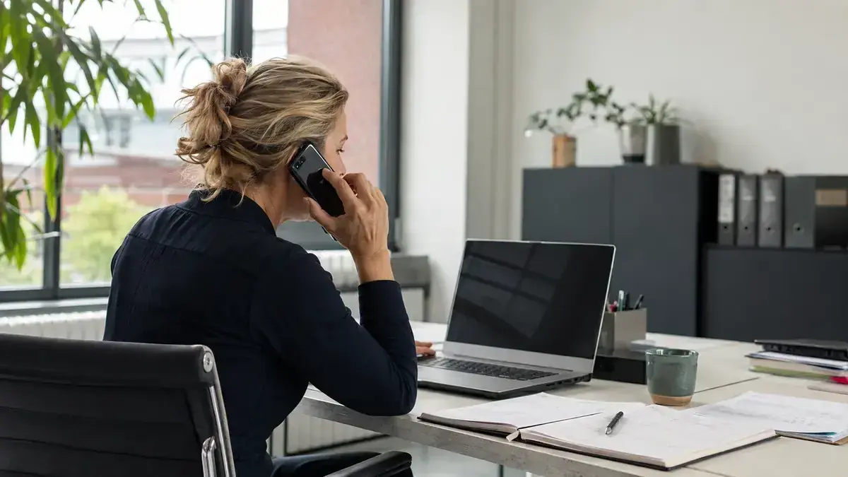 Unternehmer im telefonischen Austausch am Laptop mit Kalender und Fristmarkierung – Symbolbild zum Beitrag „Ausstehende Forderungen nach Fälligkeit: Was am ersten, siebten und 14. Tag zu tun ist“.