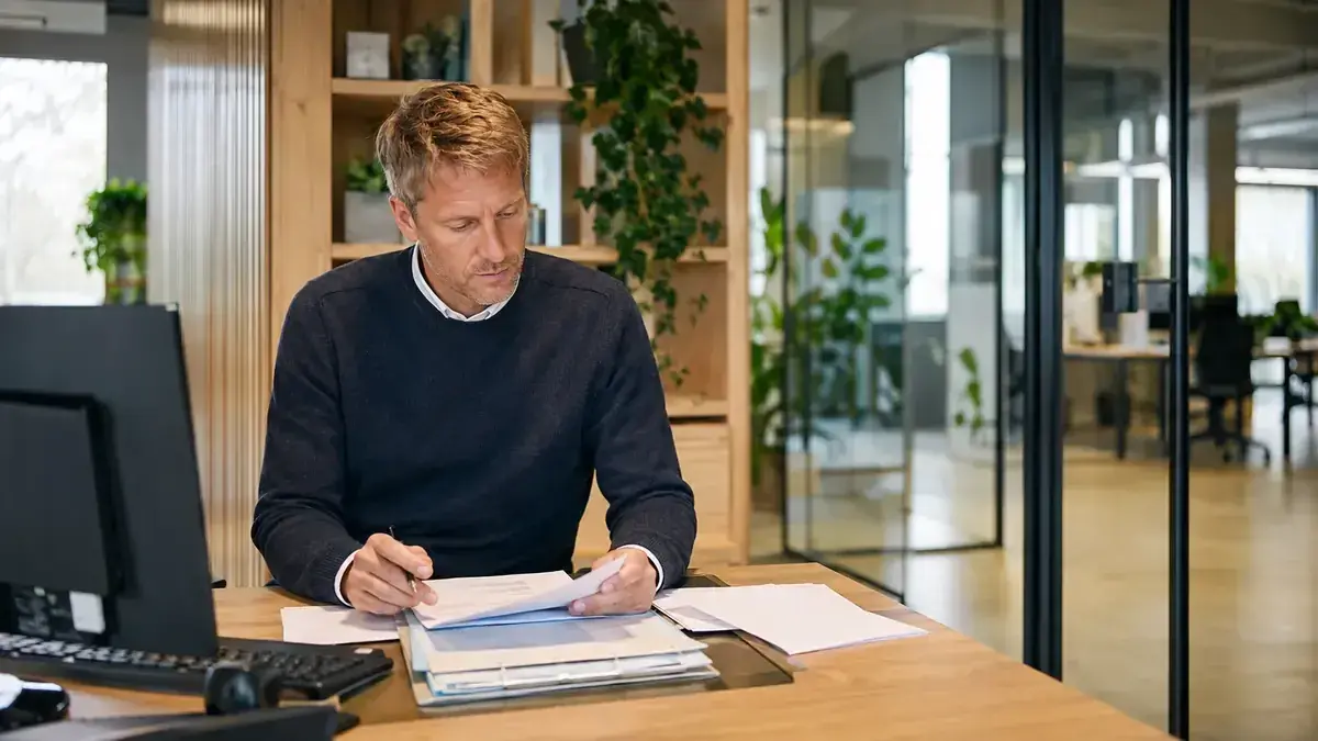 Mitarbeiterin mit Smartphone in einem transparenten modernen Büro mit digitalem Prozessnetzwerk.