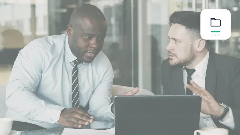 zwei Fachleute bei der gemeinsamen Prüfung eines Geschäftsvorgangs mit geordnetem digitalen Forderungsordner – Symbolbild zum Beitrag „Forderungsmanagement beginnt bei der Rechnung: Fehler vor Fälligkeit vermeiden“.