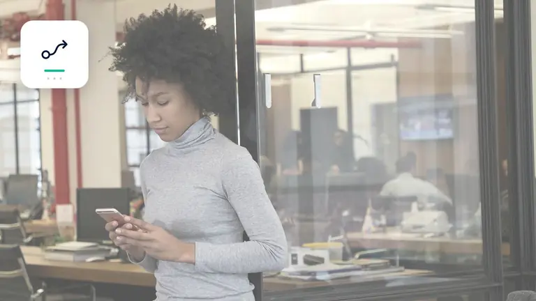 Mitarbeiterin mit Smartphone in einem transparenten modernen Büro mit strukturiertem Prozessdiagramm – Symbolbild zum Beitrag „Forderungsmanagement Governance: Verantwortlichkeiten zwischen Vertrieb, Buchhaltung und…