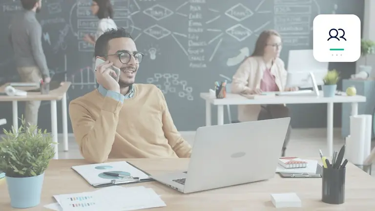 Mitarbeiter im modernen Büro mit Laptop und Telefon mit persönlicher Geschäftskommunikation – Symbolbild zum Beitrag „Forderungsmanagement kundenfreundlich gestalten: Konsequenz ohne unnötige Härte“.
