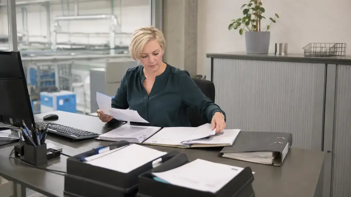 sortierte Rechnungen und Geschäftsunterlagen mit geordnetem digitalen Forderungsordner – Symbolbild zum Beitrag „Forderungsmanagement mit abgestuftem Mahnwesen: Zeitpunkt, Kanal und Ton“.