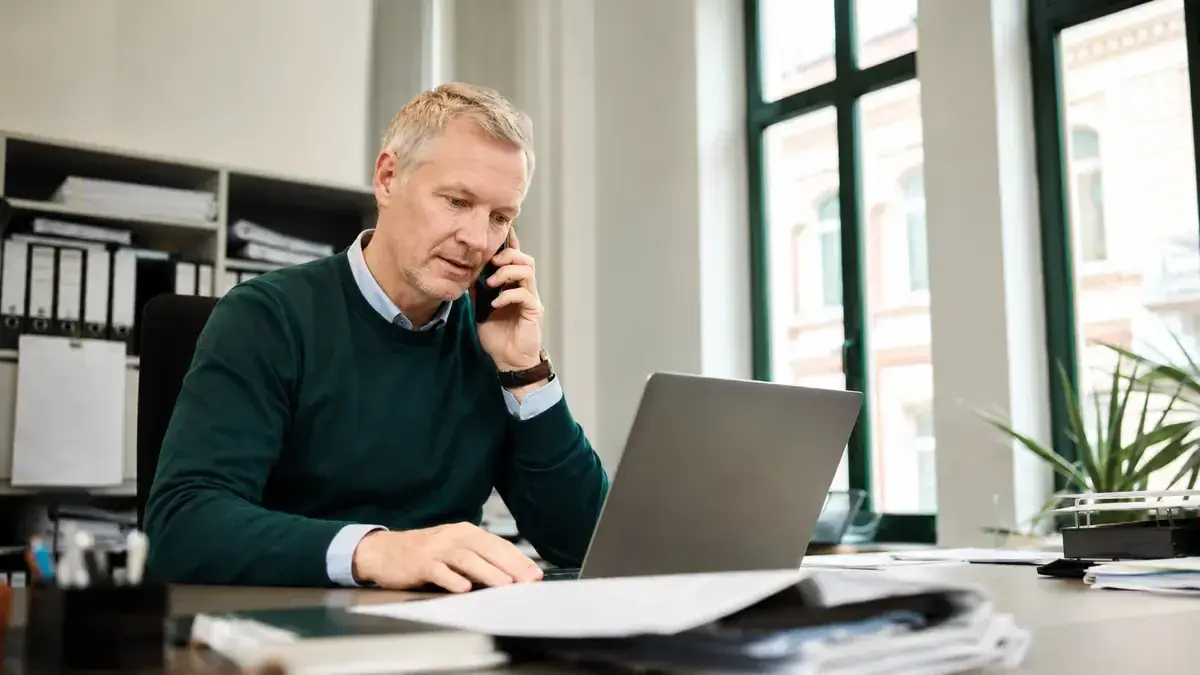 Mitarbeiterin im telefonischen Kundengespräch an einem Laptop mit Adress- und Recherchemarkierung – Symbolbild zum Beitrag „Inkasso bei unbekannter Schuldneradresse: So funktioniert die Adressermittlung“.