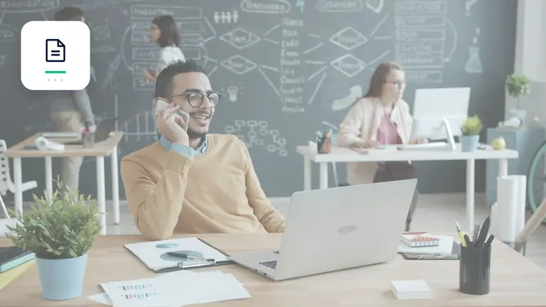 Profesional en una oficina moderna con portátil y teléfono con documento de factura digital – imagen editorial para «Cobro de deudas para agencias y freelancers: cómo reclamar honorarios de forma estructurada».
