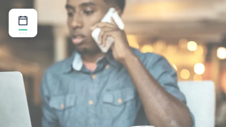 Business owner on a phone call beside a laptop with calendar and deadline marker – editorial image for “Business debt collection: the optimal process from the first day after due date”.