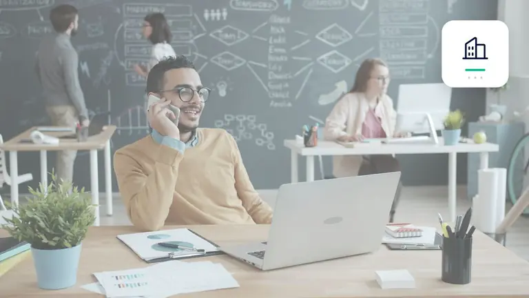 Professional in a modern office with a laptop and phone with business building symbol – editorial image for “Business debt collection toward public-sector clients: special points for payment deadlines”.