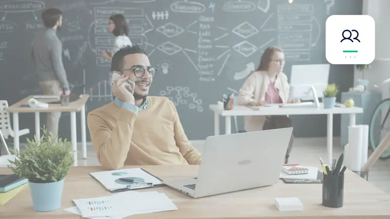 Professional in a modern office with a laptop and phone with personal business communication – editorial image for “Business debt collection without losing customers: measured escalation”.