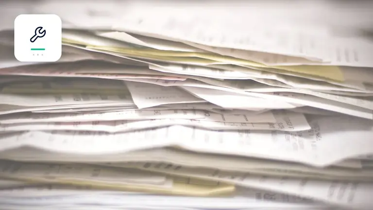 Facturas y documentos empresariales ordenados con símbolo de herramientas y documentación – imagen editorial para «Cobro de deudas en oficios: cómo asegurar créditos pese a una relación activa con el cliente».
