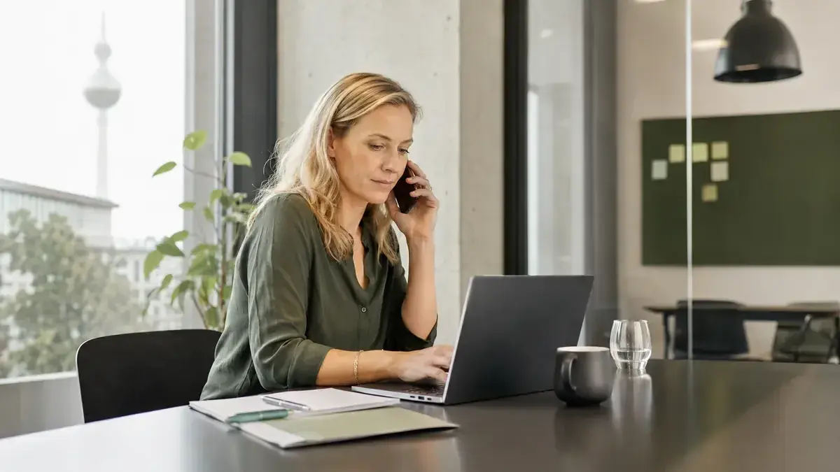 Mitarbeiterin im telefonischen Kundengespräch an einem Laptop mit persönlicher Geschäftskommunikation – Symbolbild zum Beitrag „Rechnung wird nicht bezahlt: So bleibt die Kundenbeziehung trotzdem intakt“.