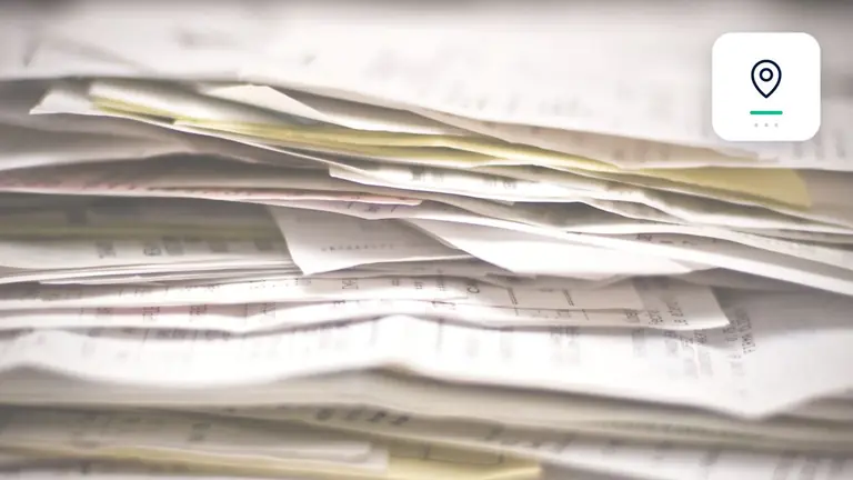 Facturas y documentos empresariales ordenados con marcador de domicilio e investigación – imagen editorial para «Factura no pagada y la dirección es desconocida: siguientes pasos».