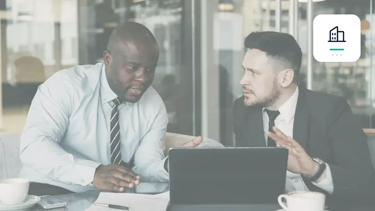 Dos profesionales revisando conjuntamente un asunto empresarial con símbolo de empresa – imagen editorial para «Factura no pagada de un cliente empresarial: derechos B2B de un vistazo».