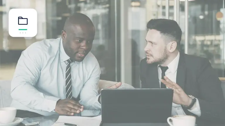 Dos profesionales revisando conjuntamente un asunto empresarial con carpeta digital ordenada de cobros – imagen editorial para «Factura no pagada, porque el cliente es insolvente: qué puede seguir siendo posible».